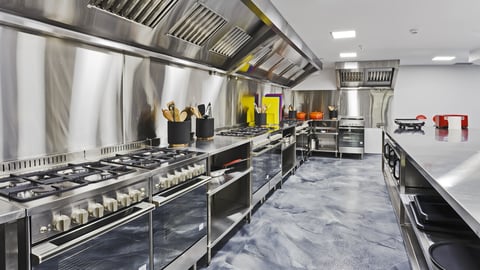 Modern shiny kitchen with stainless still kitchenware and equipment for restaurant-scale cooking with preparation tables, pans, pots, stoves.; Shutterstock ID 605311271